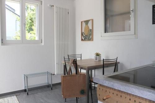 图恩NEB-THUN Studio am Thunersee的厨房以及带桌椅的用餐室。