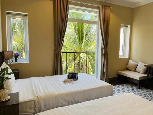 会安Kemi House Hoi An的酒店客房设有两张床和窗户。