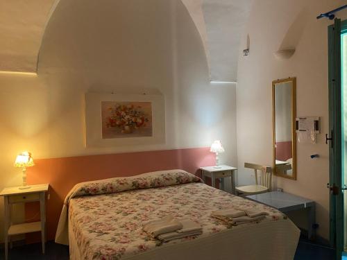 托雷圣乔万尼乌Araucaria的一间卧室配有床、两张桌子和镜子