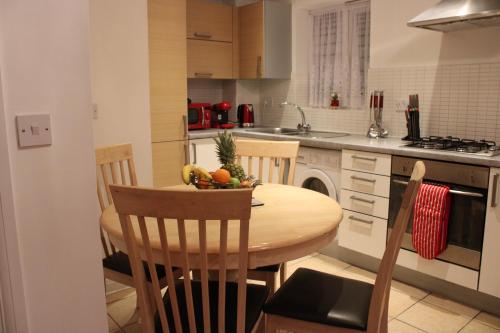 达格纳姆Eldridge Court Apartment的厨房配有木桌,上面放着一碗水果