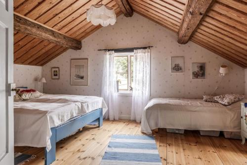 永比Nice cottage in Bolmstad outside Ljungby的一间卧室设有两张床和窗户。