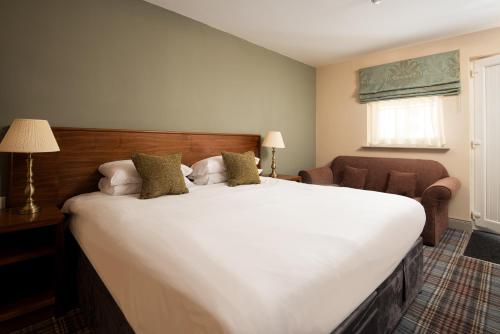 BealThe Lindisfarne Inn - The Inn Collection Group的卧室配有一张白色大床和一把椅子