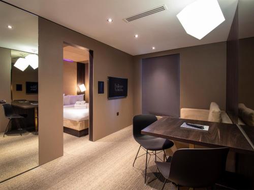 伯明翰Bloc Hotel Birmingham的酒店客房带一张床、一张桌子和椅子