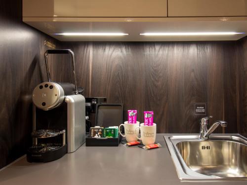 伯明翰Bloc Hotel Birmingham的厨房柜台配有水槽和咖啡壶