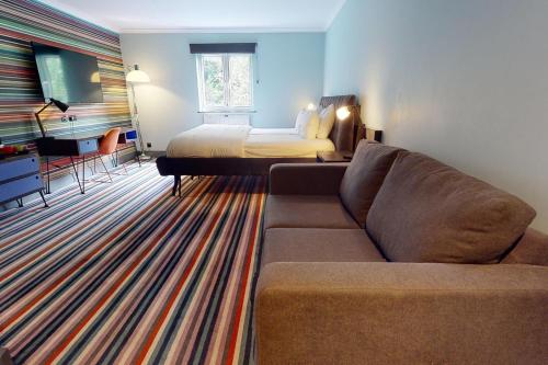 卡迪夫加的夫乡村酒店的客厅配有沙发和1张床