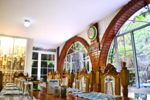 圣萨尔瓦多绿洲住宿加早餐旅馆的一间带桌子和一些窗户的用餐室
