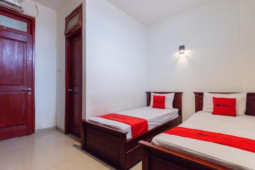 泗水RedDoorz @ Raya Ngagel 2的一间卧室配有两张带红色枕头的床