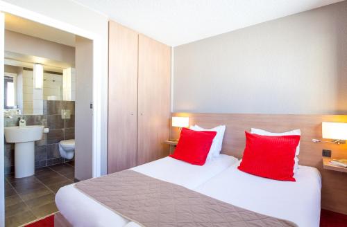 伊索拉2000SOWELL HOTELS Le Pas du Loup的配有两张红色枕头的床的酒店客房