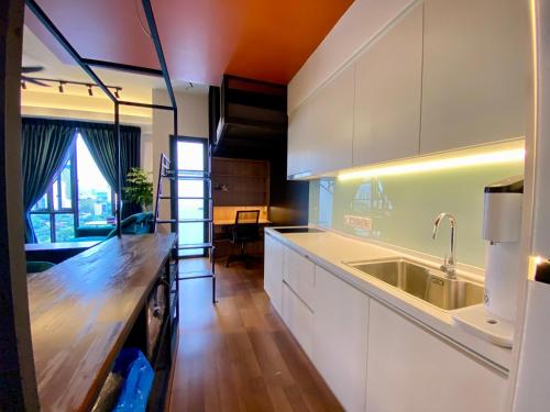 吉隆坡Sentral Suites By RKD HOME的厨房配有白色橱柜和木制台面