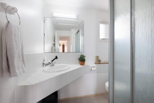 ShakaskraalSantorini Perissa Seaview Apartment的白色的浴室设有水槽和镜子