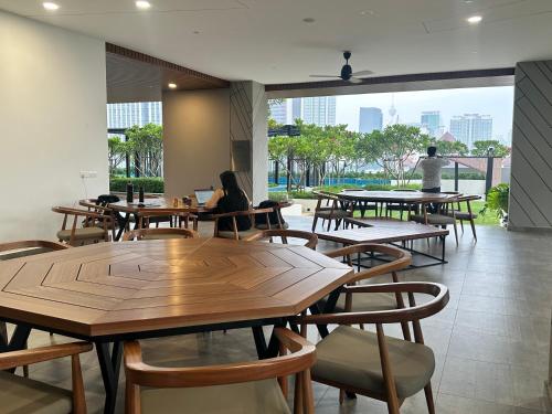 吉隆坡Sentral Suites KualaLumpur的餐厅设有木桌、椅子和大窗户。