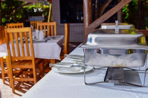 育空河Mzunguu Safari Lodge的餐桌上摆有盘子的烤架