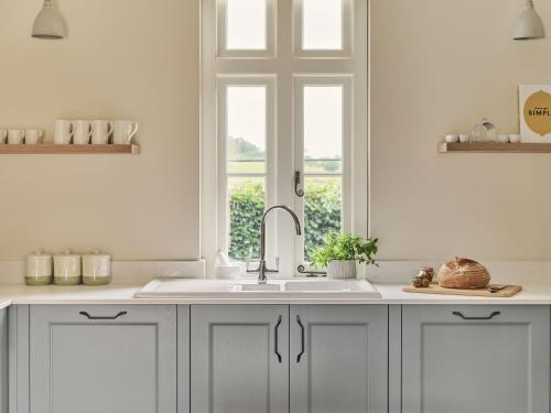 赫特福德Bridge House at Woodhall Estate的白色的厨房设有水槽和窗户
