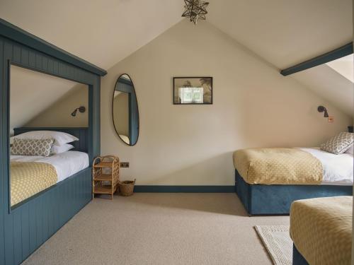 赫特福德Bridge House at Woodhall Estate的阁楼卧室配有两张床和镜子