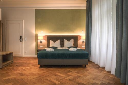 雷达-维登布吕克VillaWie的一间卧室配有带绿色床单和白色枕头的床