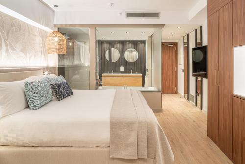 美洲海滩安东尼爵士酒店的一间卧室配有一张大床和电视