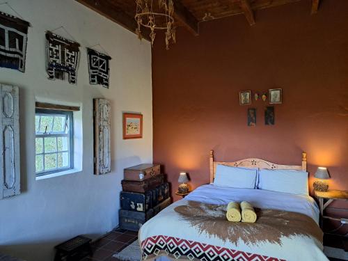 莱迪史密斯Wolverfontein Karoo Cottages的一间卧室配有一张带两张木柴的床。