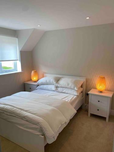 切尔滕纳姆Cotswold Cottage的一间卧室配有白色床和2个床头柜