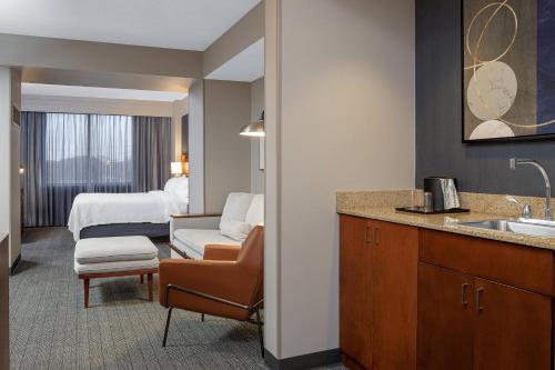 朗康科马长岛麦克阿瑟机场万怡酒店的酒店客房设有水槽和一间卧室
