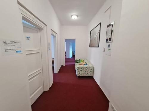 华沙Fantastic Apartments - NW9 Room - 3的走廊上设有红色地板,走廊上设有椅子