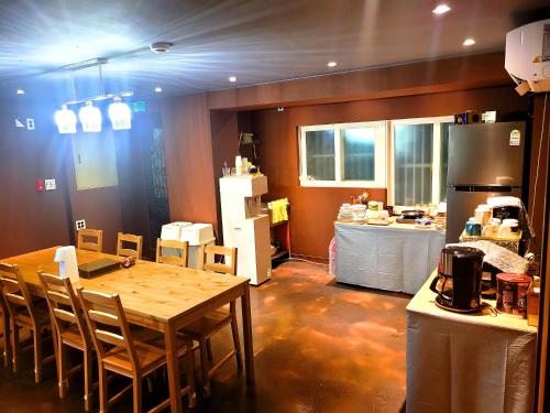 首尔Good Guesthouse的一间带桌子的厨房和一间带冰箱的厨房