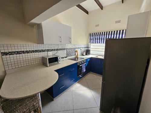 圣卢西亚14 Manzini Chalets -Flamingo Cove的一间小厨房,内配蓝色橱柜和水槽