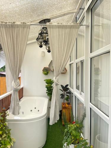 Mon JamPhu Morinn Cafe&Camping的带浴缸的浴室和窗帘