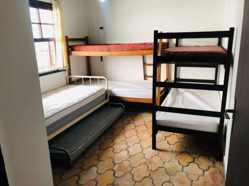 瓜鲁雅Casa na Enseada- Guaruja的客房设有两张双层床和一扇窗户。