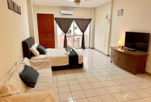 武吉丁宜Bukit Tinggi 1 Hati guesthouse的客房设有两张床、一台电视和一张沙发。