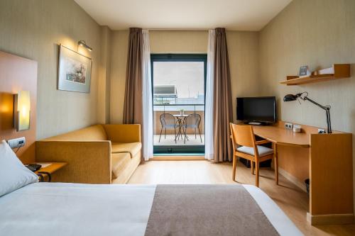 马拉加马拉加西班牙波萨达斯酒店的酒店客房配有一张床、一张书桌和一台电视。