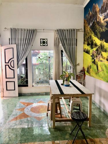 外南梦Ohana Homestay Banyuwangi的一间房间,墙上挂着一张桌子和一幅画