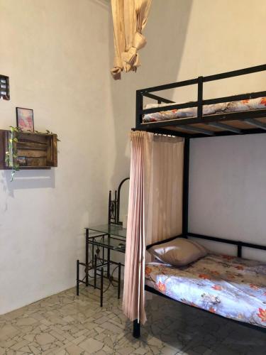 外南梦Ohana Homestay Banyuwangi的一间卧室设有两张双层床和一张桌子