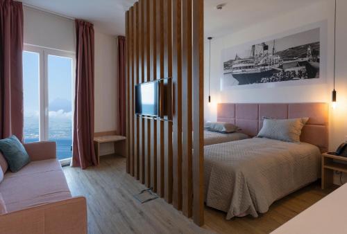 奥尔塔Horta Bay的一间卧室配有一张床、一台电视和一张沙发