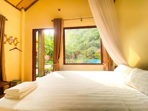 宁平Tam Coc Rocky Bungalow的一间卧室设有一张大床和窗户