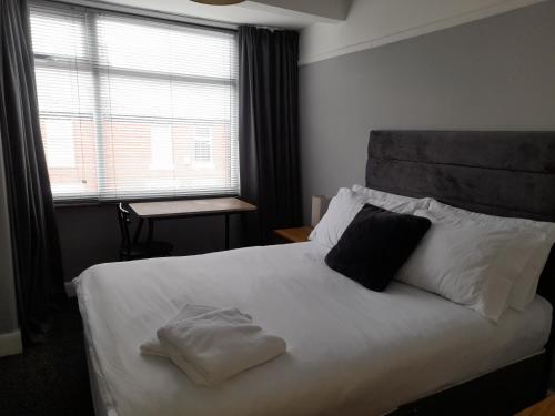 曼彻斯特Bright 4-Bed house 15 min to Manchester Centre的卧室配有一张带两个枕头的大白色床