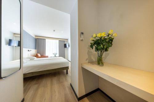 曼亚拉Saaremaa Rannahotell ' Beach Hotel的一间卧室,配有一张床和黄色花瓶