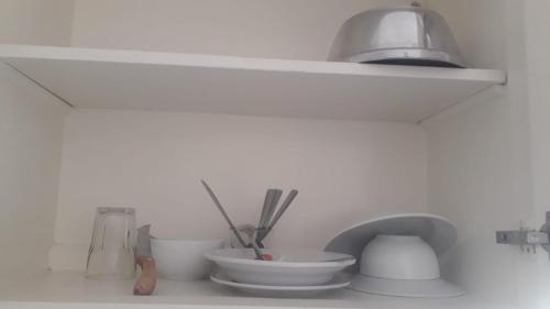 赫尔格达Moubark 6 studio 3的厨房柜台上摆放着碗和餐具的架子