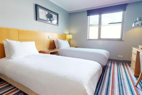 斯旺西斯旺西乡村酒店的酒店客房设有两张床和窗户。
