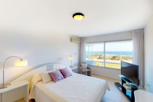 埃斯特角城Oceana Suites en Esturion, frente a playa Brava的一间卧室设有一张床和一个海景窗户
