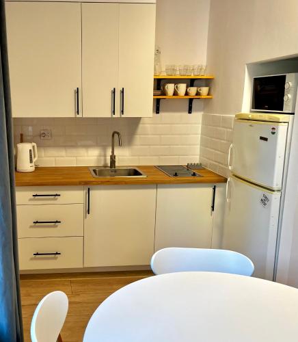 华沙OhMyHome - Hala Mirowska的厨房配有白色橱柜和白色冰箱。