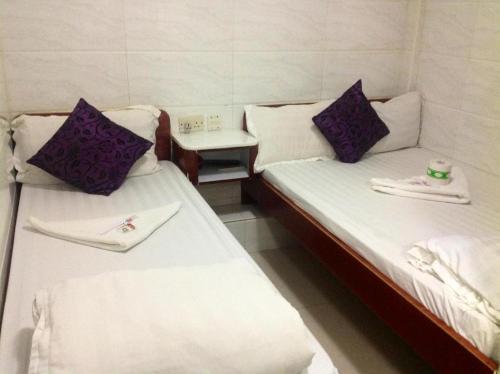 香港Relaince Inn的配有两张床铺、毛巾和桌子的客房