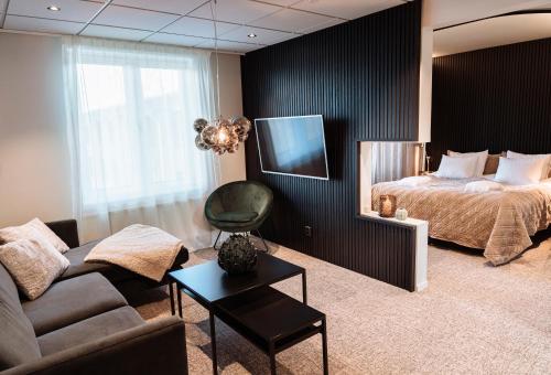 布拉斯泰德范恩温泉酒店与会议中心的客厅配有床、沙发和电视