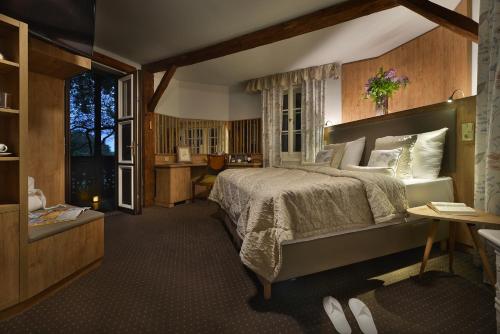 娄切尼卢森花园城堡酒店的一间卧室设有一张大床和一个窗户。