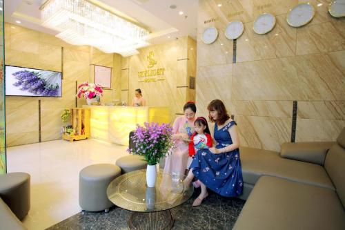 芽庄Skylight Hotel Nha Trang的两个女人和一个小女孩在花房里