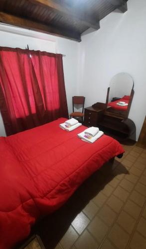 马拉圭Eduardo的红色的床,配有红色毯子和椅子