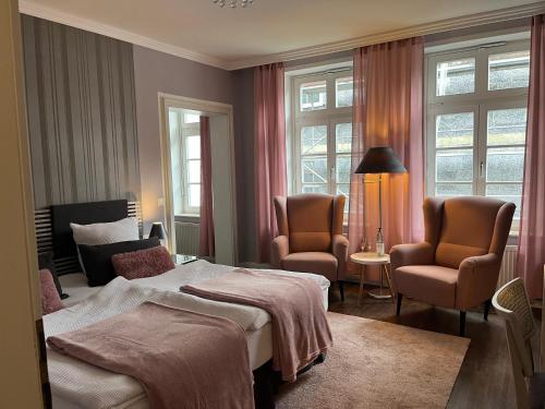 巴特皮尔蒙特Rein Klassik Hotel的酒店客房,配有一张床和两把椅子