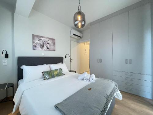 雅典Urban Oasis in Ellinikon - Athenean BnB的卧室配有白色大床和橱柜