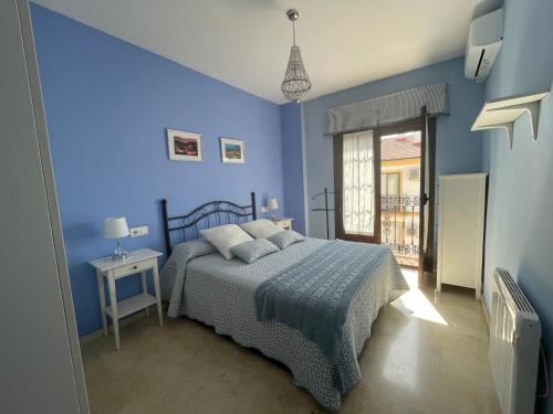 隆达Apartamento Alameda del Tajo III Centro Parquing的蓝色的卧室设有床和窗户