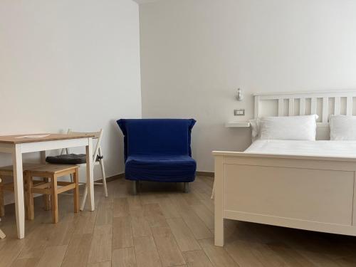 罗卡拉索Cristallo di neve b&b的一间卧室配有一张床、一张桌子和一把蓝椅