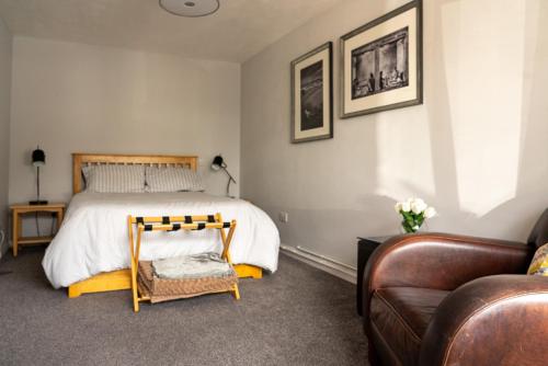 伯纳姆Nr WINDSOR stunning 1 bedroom self contained property in Burnham near Heathrow的一间卧室配有一张床、一把椅子和一张沙发